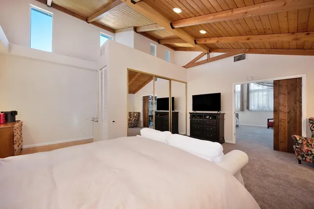 a large bedroom with a bed and a flat screen tv