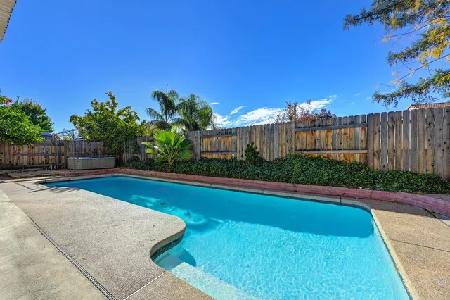 a swimming pool with outdoor seating and plants