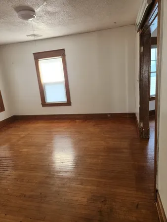 a view of a room with wooden floor and a window