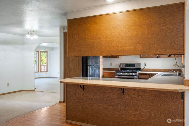a kitchen with stainless steel appliances granite countertop a sink a stove and a refrigerator