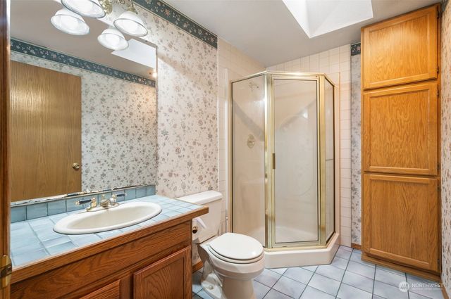 a bathroom with a granite countertop sink toilet and shower