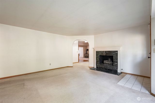 an empty room with a fireplace and a window