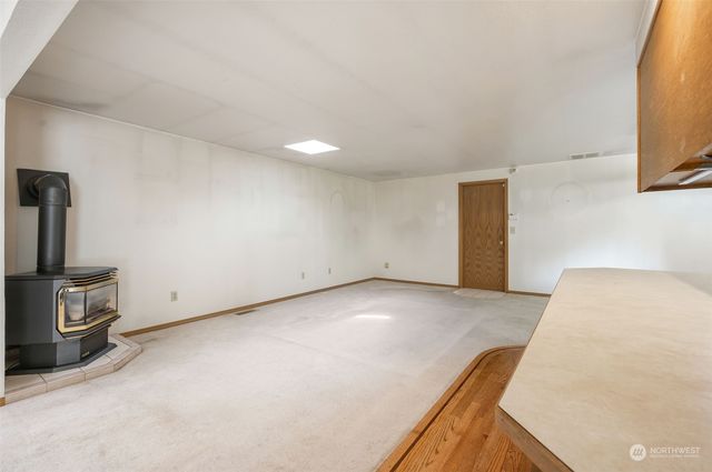 a view of a room with fridge and wooden floor