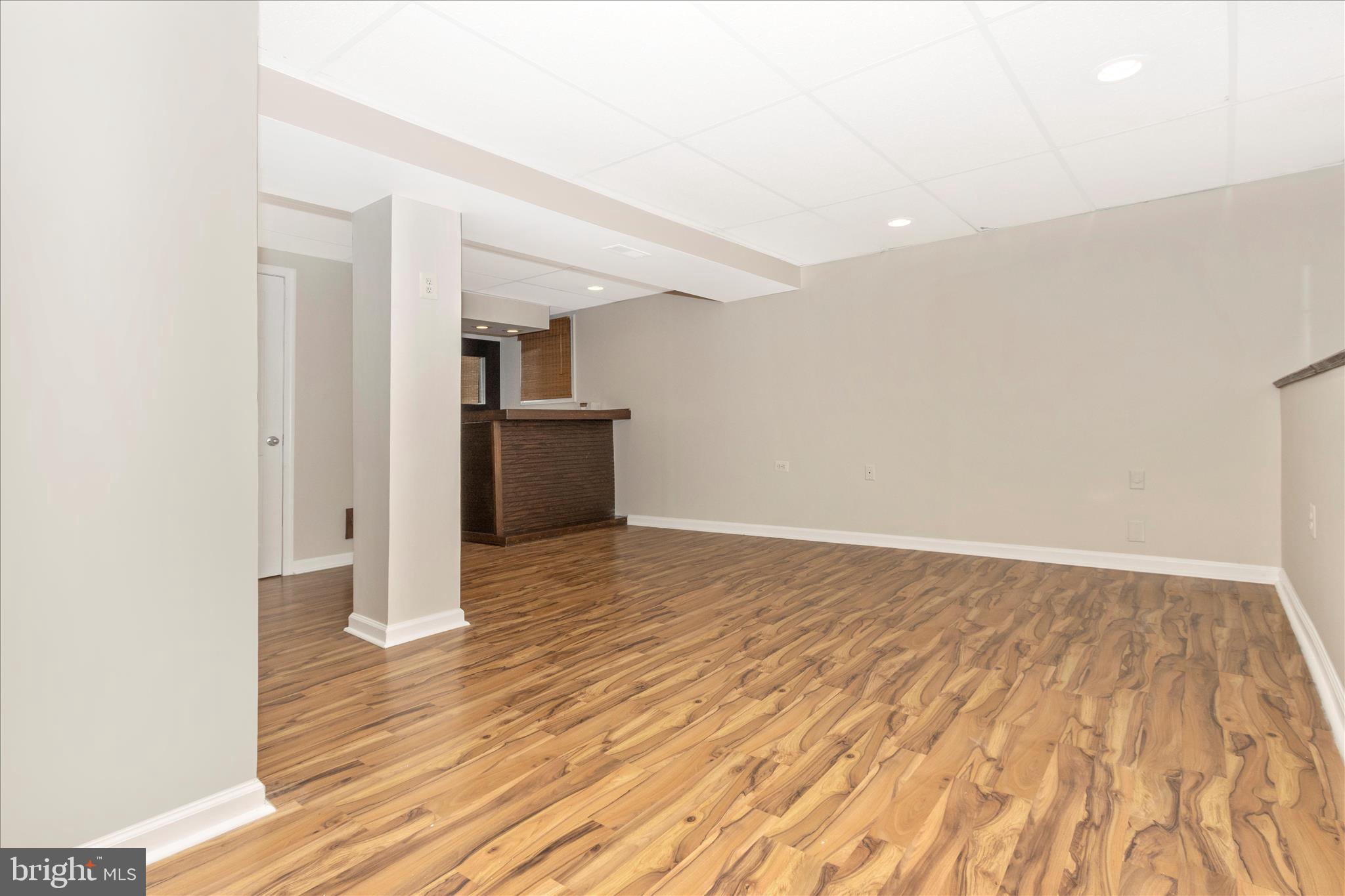 207 Contour Road Mount Airy, MD 21771 - Photo 28 of 52 a view of empty room with wooden floor and kitchen