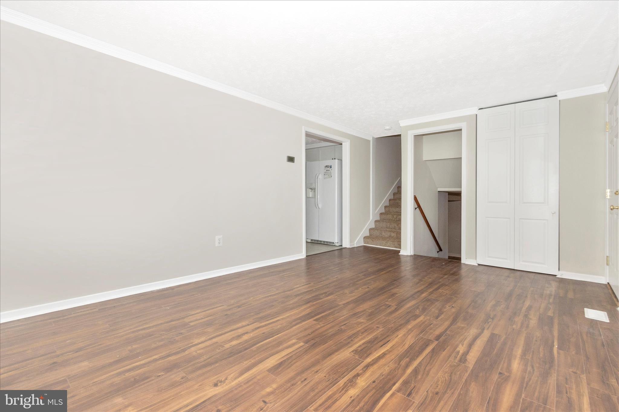 207 Contour Road Mount Airy, MD 21771 - Photo 7 of 52 an empty room with wooden floor and a ceiling fan