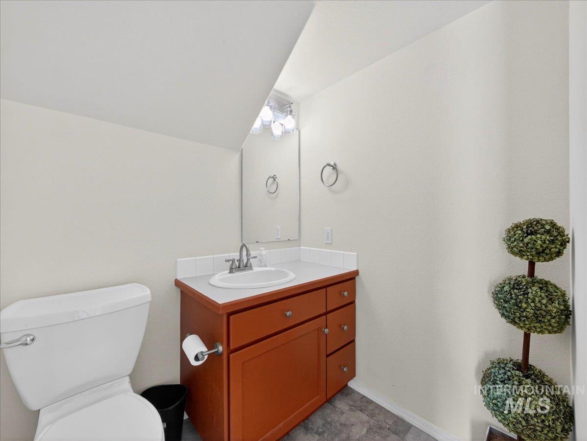 398 Pebble Beach Way Eagle, ID 83616 - Photo 13 of 35 Bathroom featuring a vanity with a wood-finish base, white countertop, and integrated sink