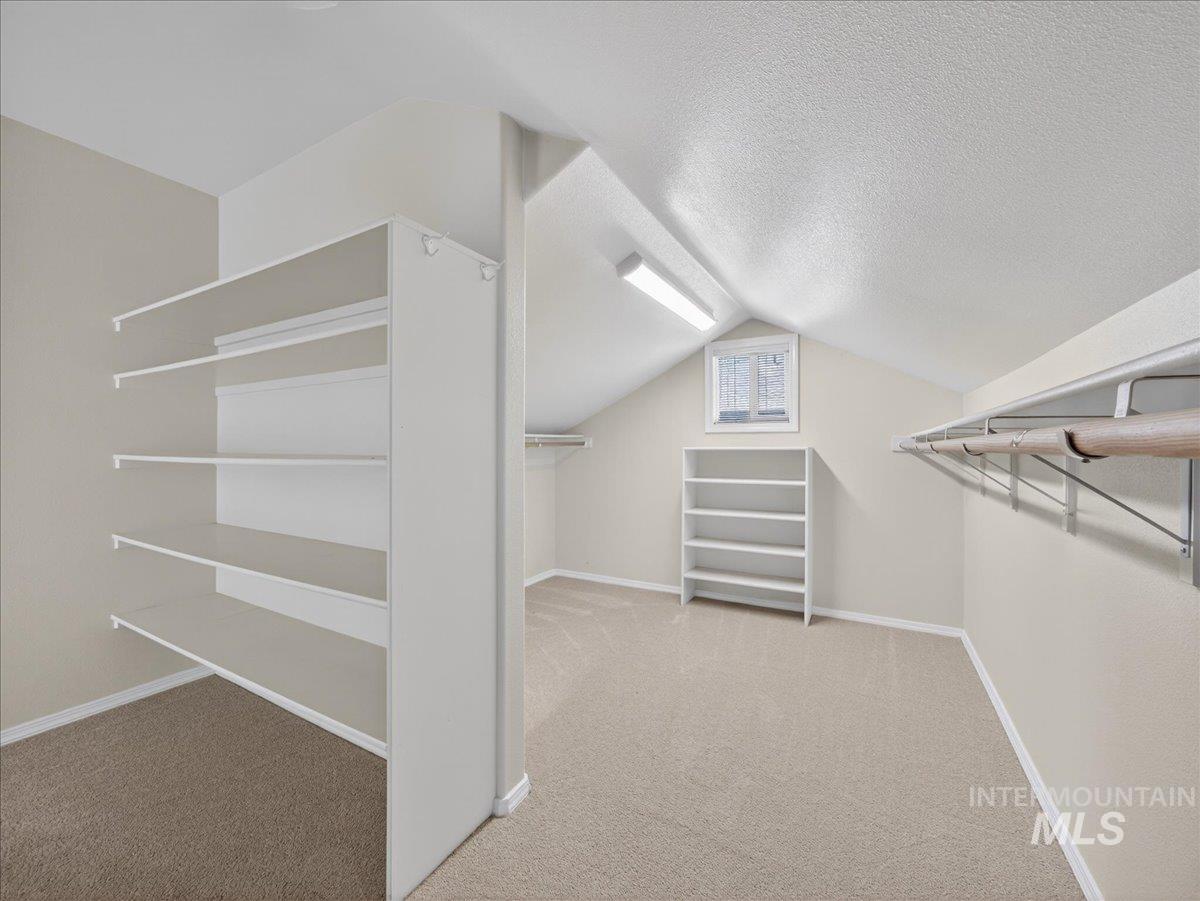 398 Pebble Beach Way Eagle, ID 83616 - Photo 17 of 35 Spacious closet featuring wall-mounted shelving, built-in clothing rods, a separate shelving unit, and a window for natural light