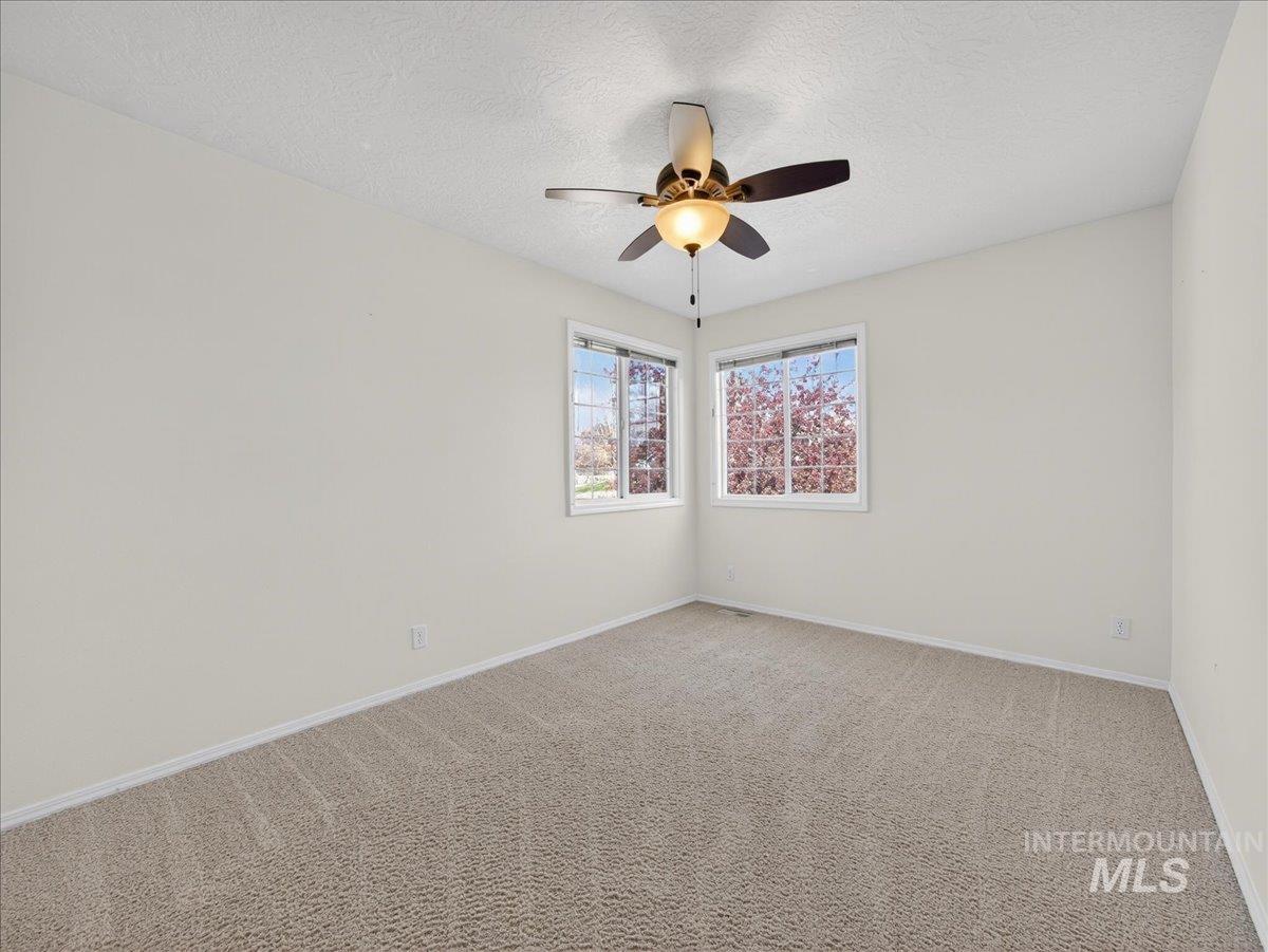398 Pebble Beach Way Eagle, ID 83616 - Photo 23 of 35 Neutral-toned carpeting and walls complement two white-framed windows