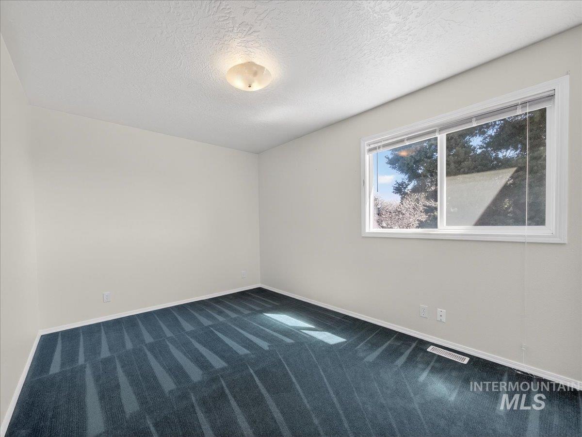 398 Pebble Beach Way Eagle, ID 83616 - Photo 27 of 35 Room featuring light-colored walls and a patterned blue carpet