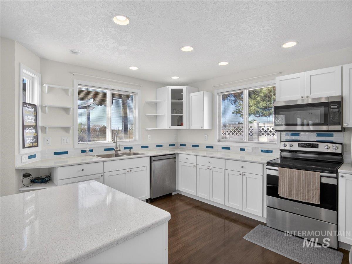 398 Pebble Beach Way Eagle, ID 83616 - Photo 10 of 35 Contemporary kitchen featuring white cabinetry, stainless steel appliances, and dark wood-finish flooring