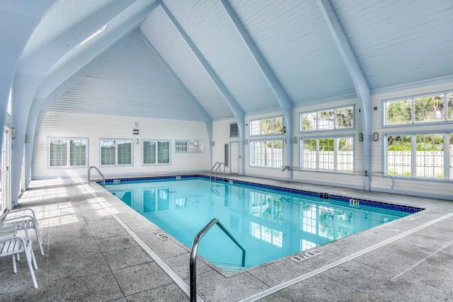 a view of a room with furniture and large windows