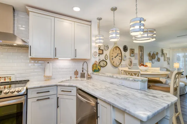 a kitchen with kitchen island granite countertop a sink a stove and cabinets