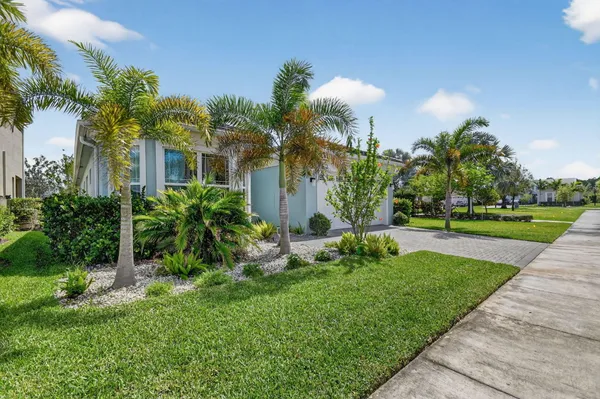 a front view of a house with a yard and potted plants
