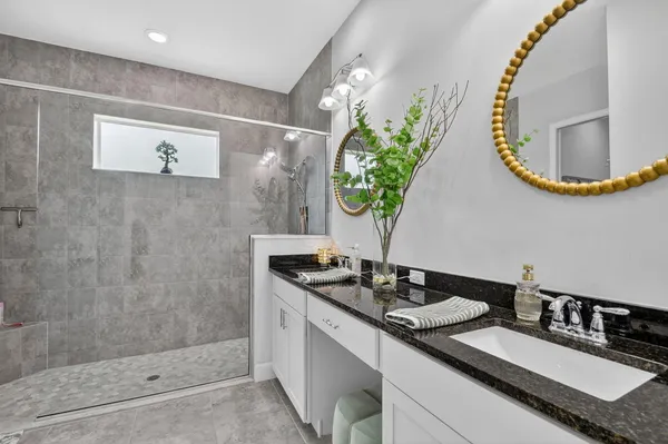 a bathroom with a granite countertop sink a toilet and a mirror