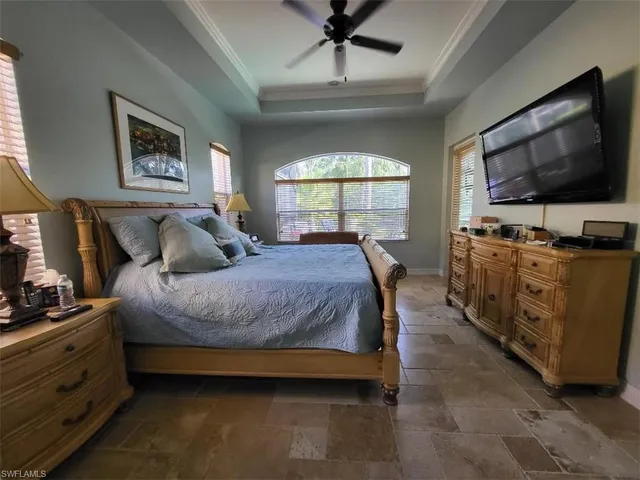a spacious bedroom with a bed and a flat screen tv