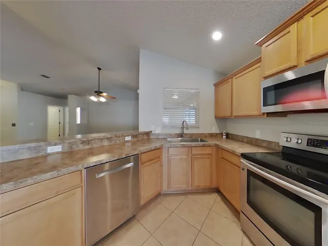 a kitchen with stainless steel appliances granite countertop a sink and stove top oven