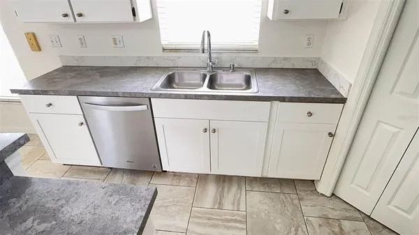 a kitchen with a sink a stove top oven and cabinets