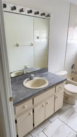 a bathroom with a granite countertop sink toilet and shower