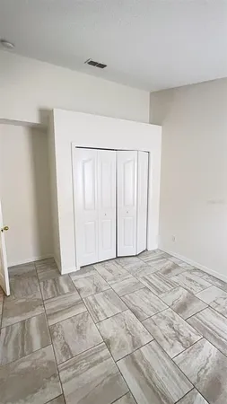 an empty room with a bench and white cabinet