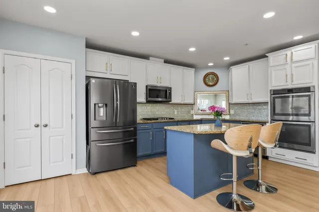 a kitchen with granite countertop a refrigerator stove top oven and sink
