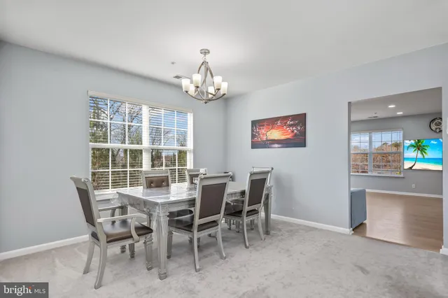 a dining room with furniture a chandelier and window