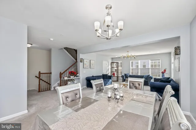 a living room with furniture chandelier and view of kitchen