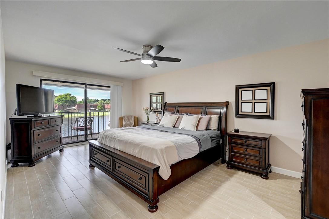 8129 Boca Rio Drive Boca Raton, FL 33433 - Photo 15 of 39 a spacious bedroom with a bed and a flat screen tv