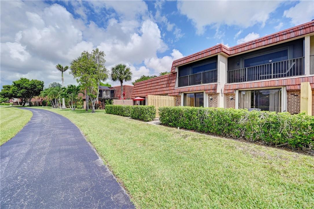 8129 Boca Rio Drive Boca Raton, FL 33433 - Photo 34 of 39 a front view of a house with yard and green space