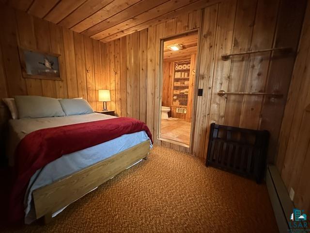 2763 Van Vac Road Ely, MN 55731 - Photo 13 of 37 Wood-paneled room featuring a wood-finish bed frame and textured carpet flooring