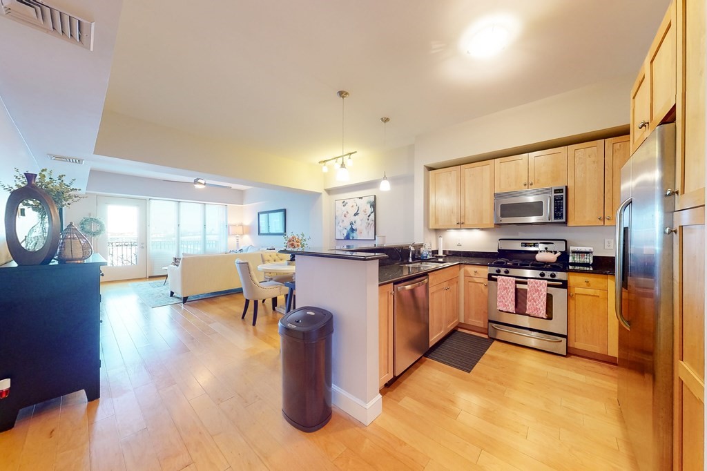 550 Pleasant Street, Unit 208 Winthrop, MA 02152 - Photo 11 of 32 a kitchen with stainless steel appliances granite countertop a refrigerator a stove top oven a sink dishwasher and cabinets with wooden floor