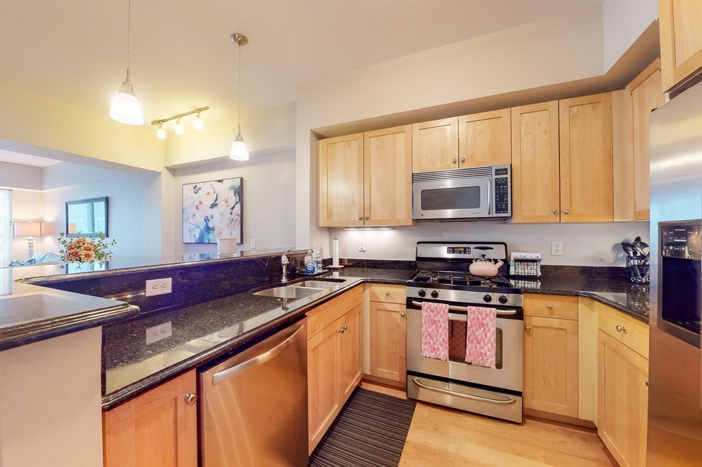 550 Pleasant Street, Unit 208 Winthrop, MA 02152 - Photo 12 of 32 a kitchen with stainless steel appliances granite countertop a sink stove and microwave