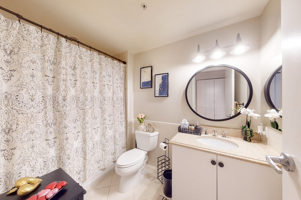 550 Pleasant Street, Unit 208 Winthrop, MA 02152 - Photo 18 of 32 a bathroom with a toilet sink vanity and mirror