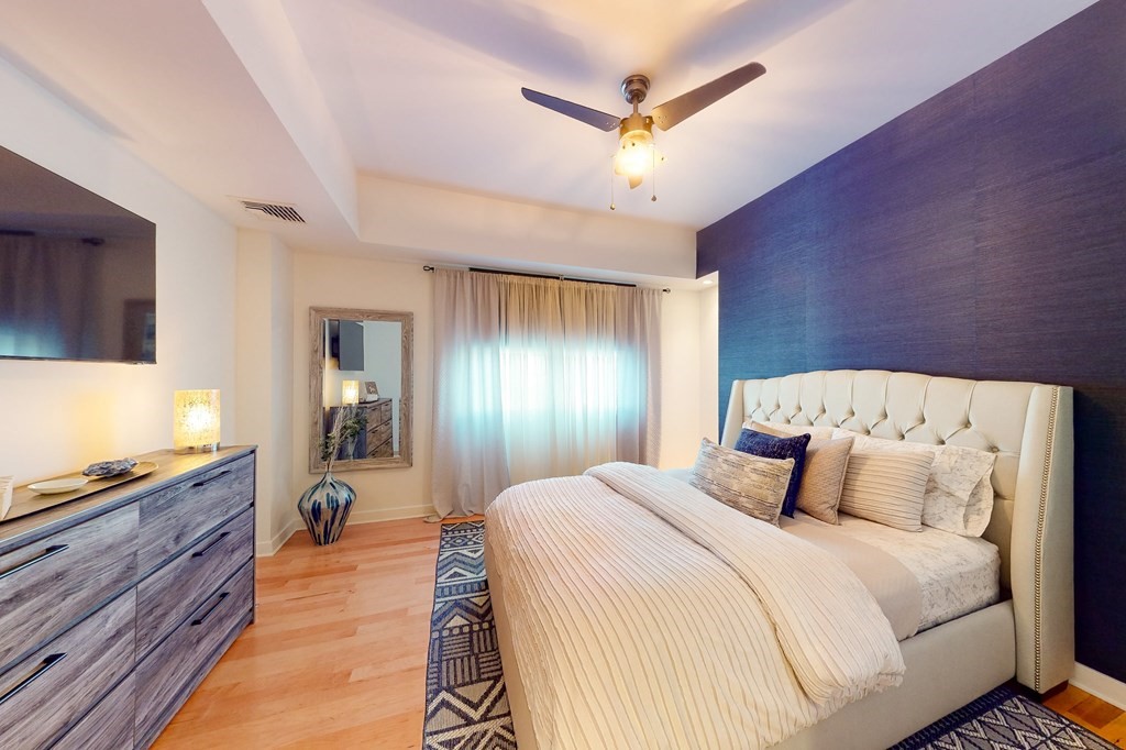 550 Pleasant Street, Unit 208 Winthrop, MA 02152 - Photo 21 of 32 a bedroom with a large bed and a chandelier