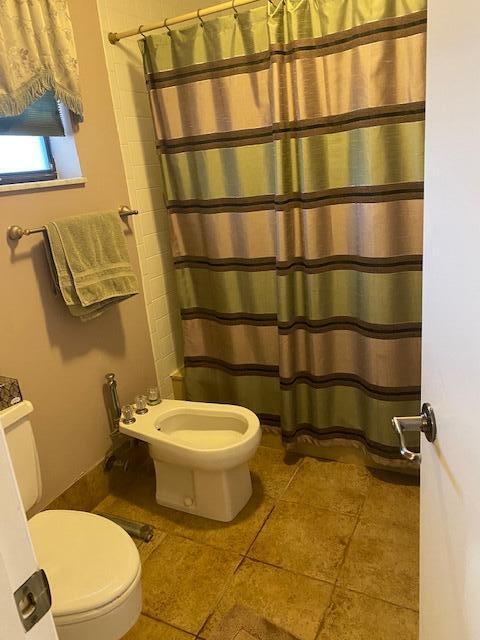 7848 Beechfern Circle, Unit 39 Tamarac, FL 33321 - Photo 6 of 19 a bathroom with a toilet and a shower curtain