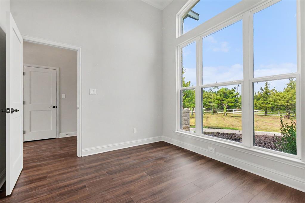 530 P R 491 Leonard, TX 75452 - Photo 5 of 35 Room featuring wood-finish flooring, white baseboards, and a large window wall with upper transom windows