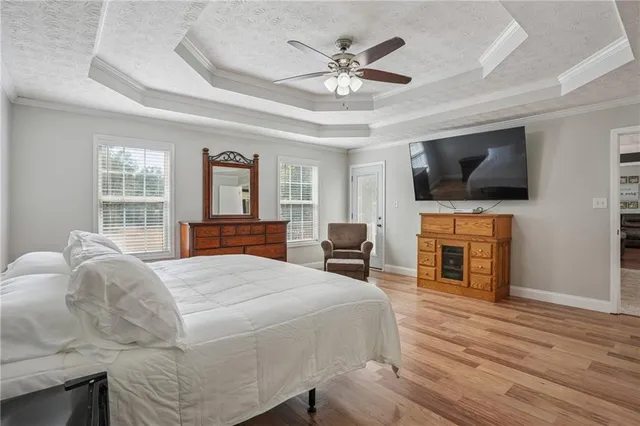 a bedroom with a bed and a flat screen tv with wooden floor