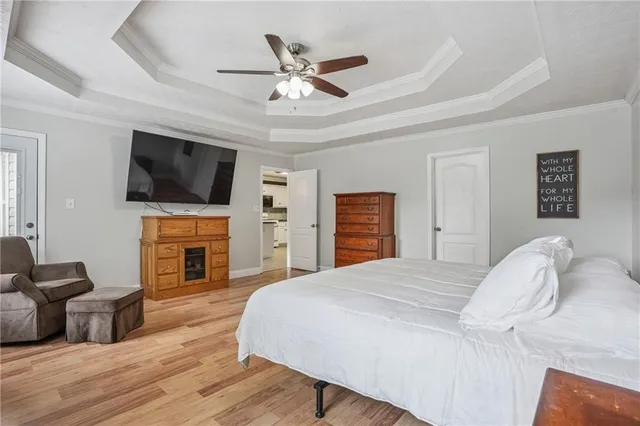 a bedroom with a bed a flat screen tv and a fireplace