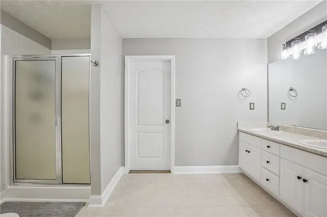 a bathroom with a double vanity sink mirror and shower