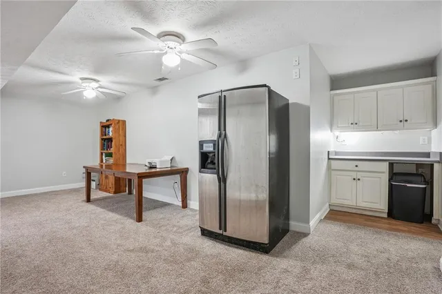 a kitchen with stainless steel appliances kitchen island a refrigerator and a chandelier