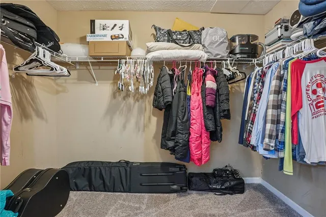 a view of walk in closet with clothes and shoes