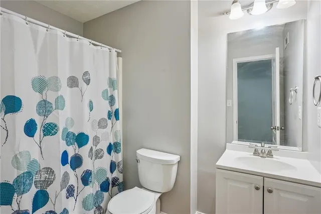 a bathroom with a sink and mirror with toilet