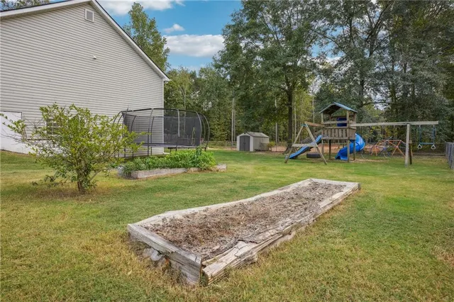 a view of a backyard with furniture and garden