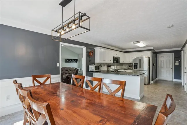 a dining room with furniture a chandelier and wooden floor