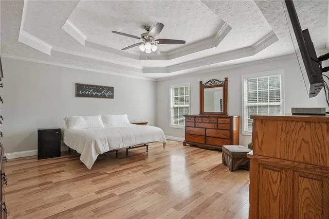 a spacious bedroom with a bed and wooden floor