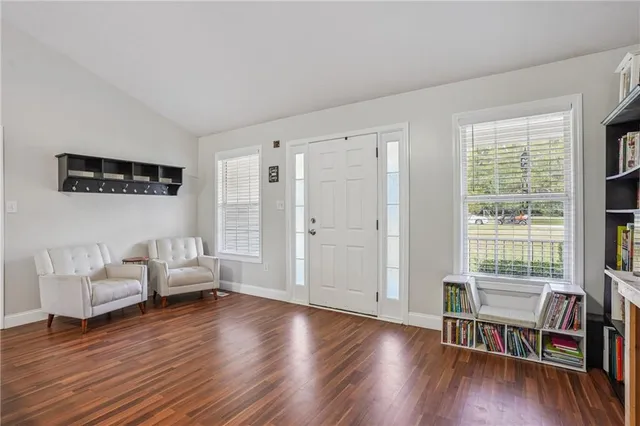 a living room with furniture wooden floor and windows