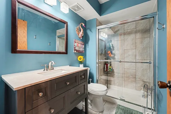 a bathroom with a sink vanity mirror and toilet