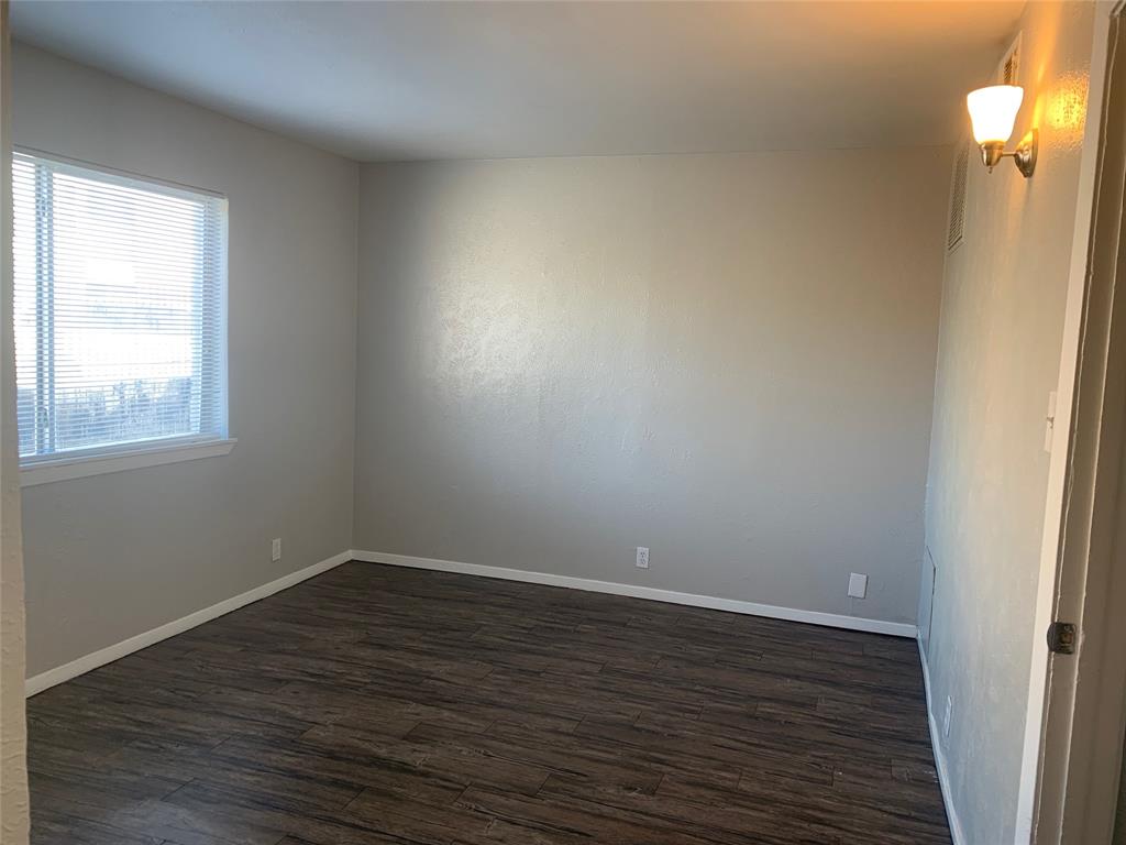 4606 Monarch Street, Unit 215 Dallas, TX 75204 - Photo 5 of 14 Spare room featuring dark wood-style flooring and baseboards