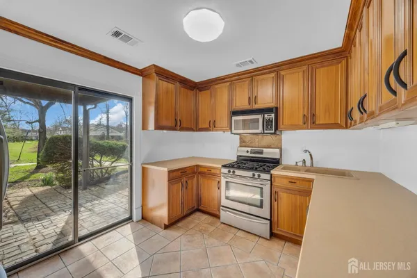 a kitchen with stainless steel appliances granite countertop a stove a sink and a refrigerator