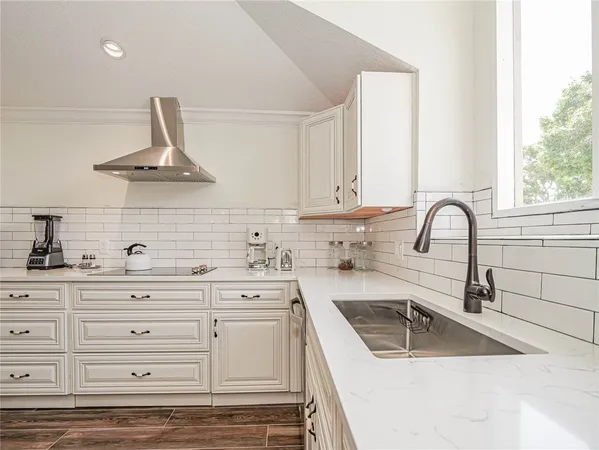 a kitchen with granite countertop a sink stainless steel appliances and cabinets