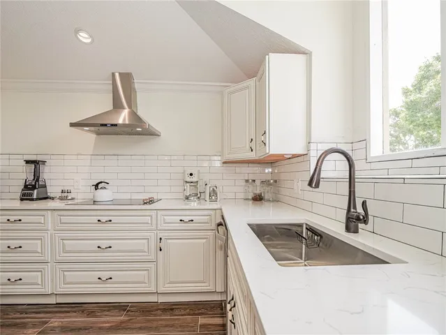 a kitchen with granite countertop a sink stainless steel appliances and cabinets